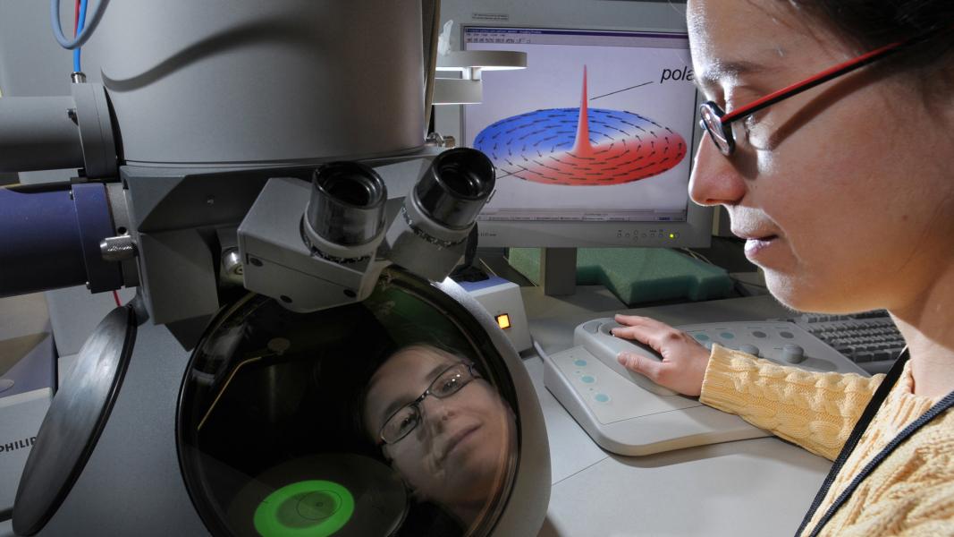 Closeup of researcher wearing glasses being reflected in equipment.